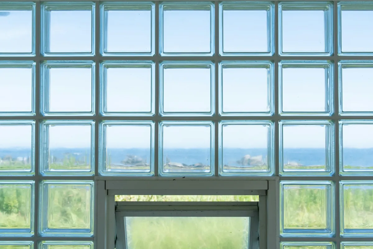 Mur en briques de verre transparentes laissant voir la mer