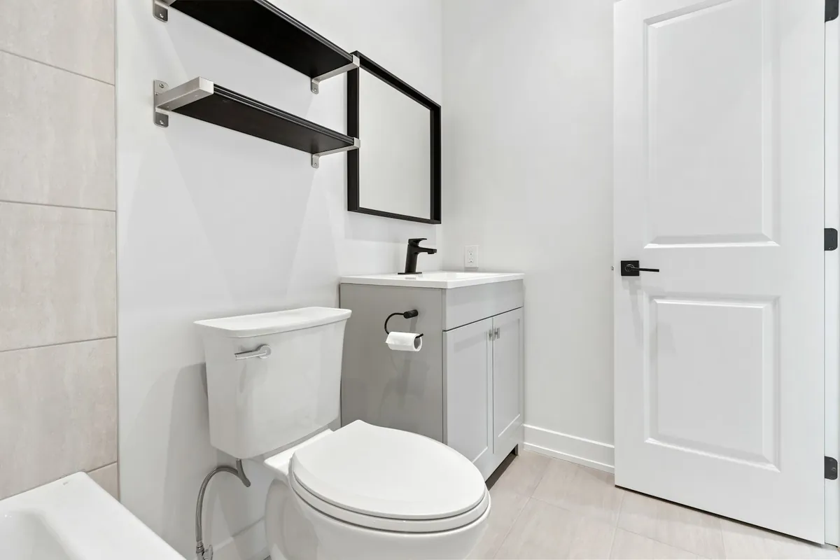 WC à l’anglaise blanc avec réservoir dans une salle de bains claire