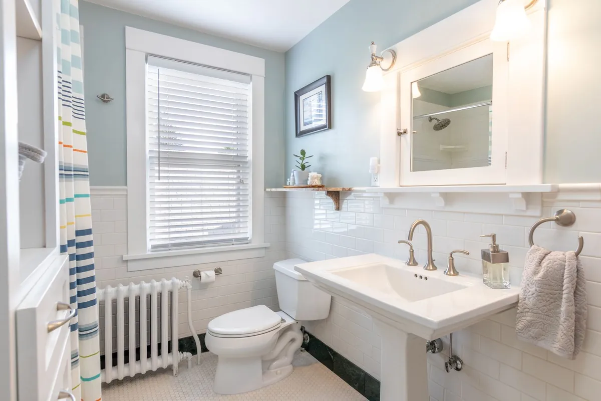Salle de bains claire avec lavabo sur colonne blanc et WC