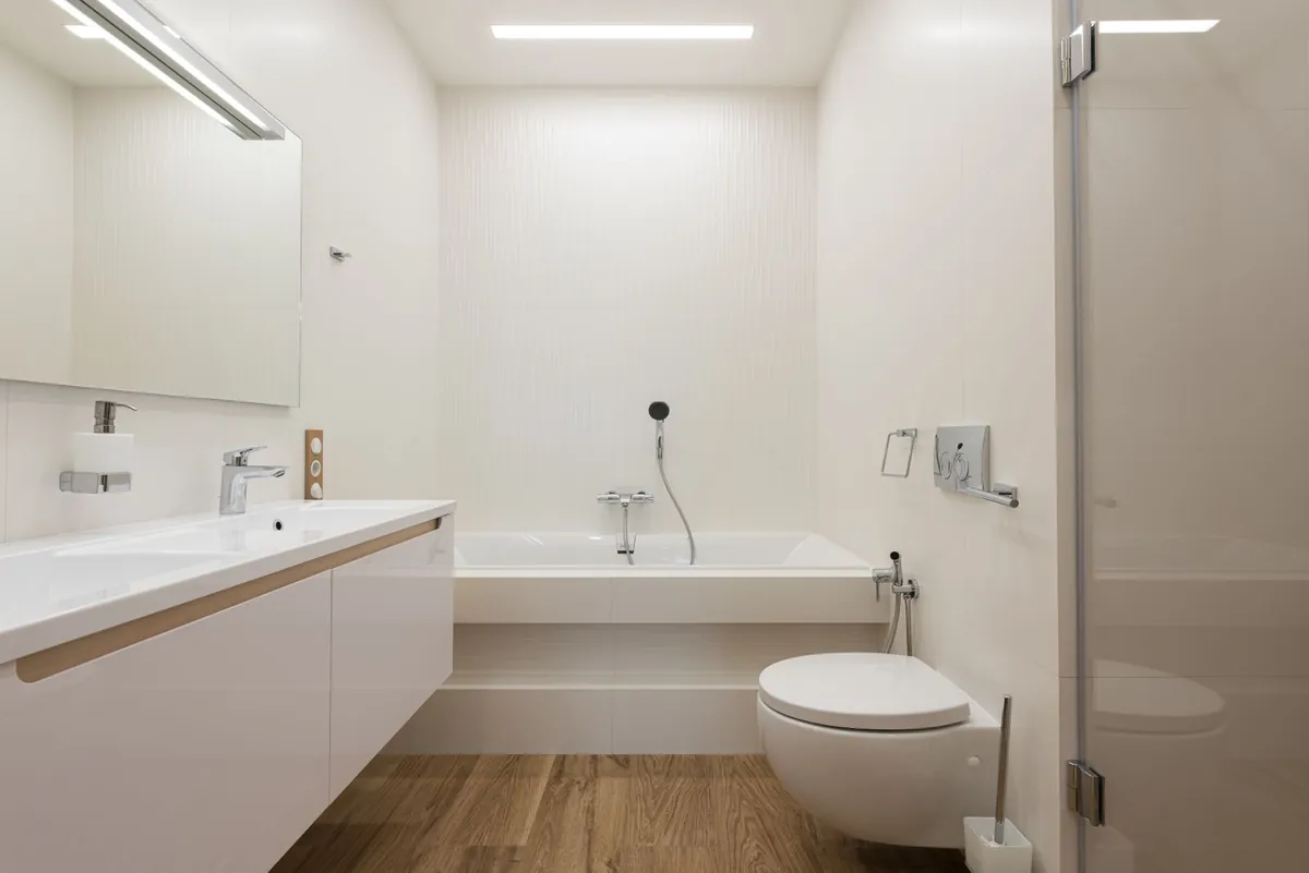 Salle de bains blanche avec meuble vasque, baignoire et WC suspendu